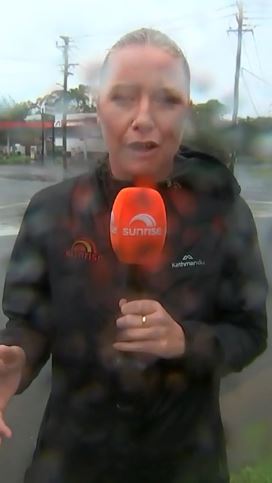 7NEWS reporter Katie Brown reporting in the rain.