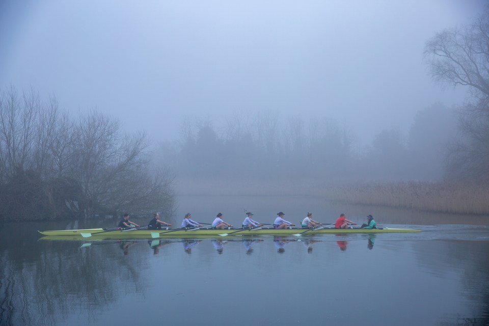 Cambridge University women's rowing team training on a foggy river.