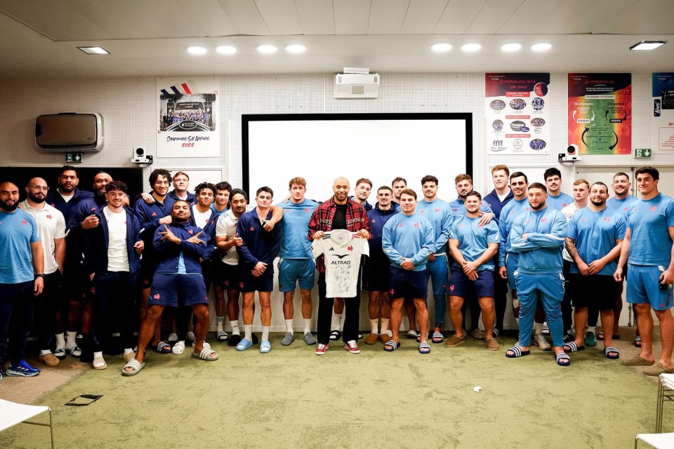 Group photo of rugby players with a signed jersey.