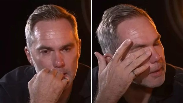 A man wiping away tears.