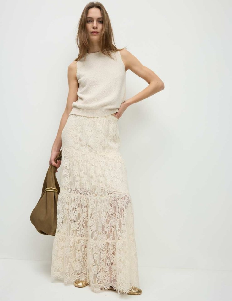 Model wearing a cream lace maxi tiered skirt and cream knit top.