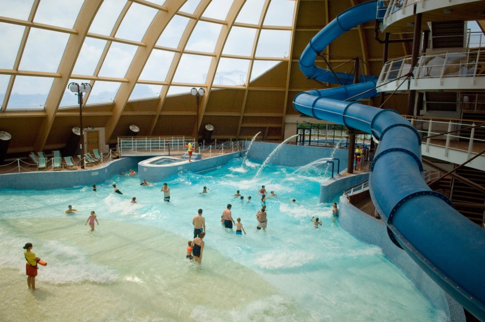 Indoor wave pool with a large blue water slide.