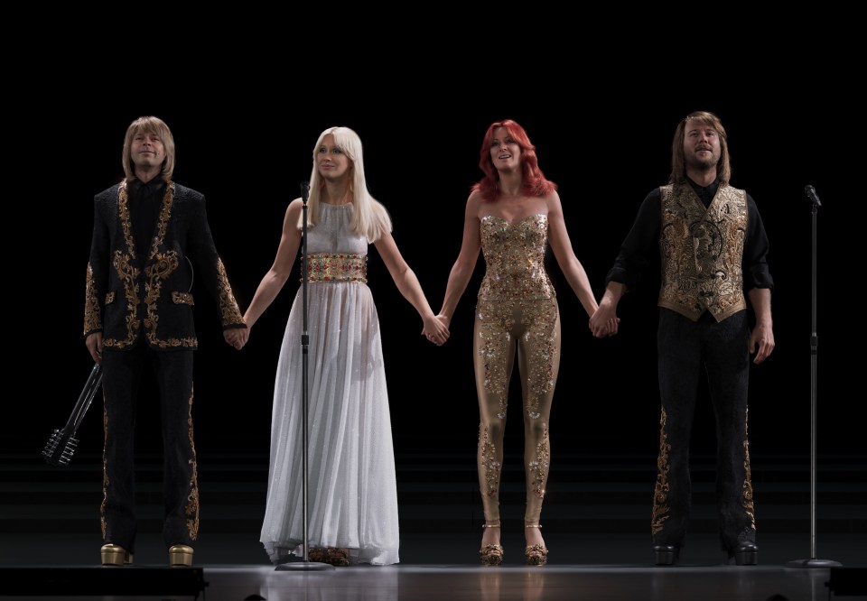 ABBA on stage holding hands.
