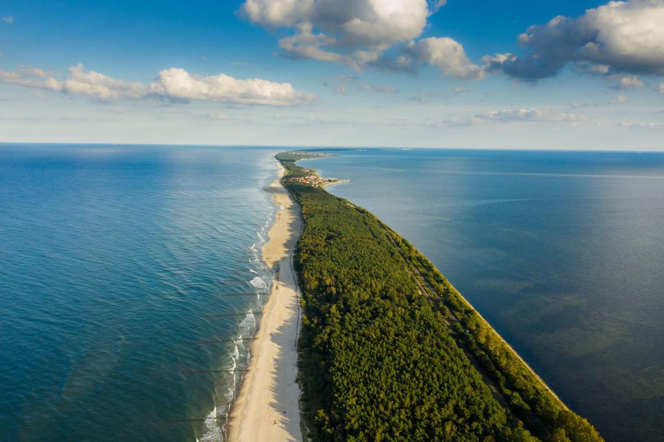 Aerial view of a long, narrow peninsula separating two bodies of water.