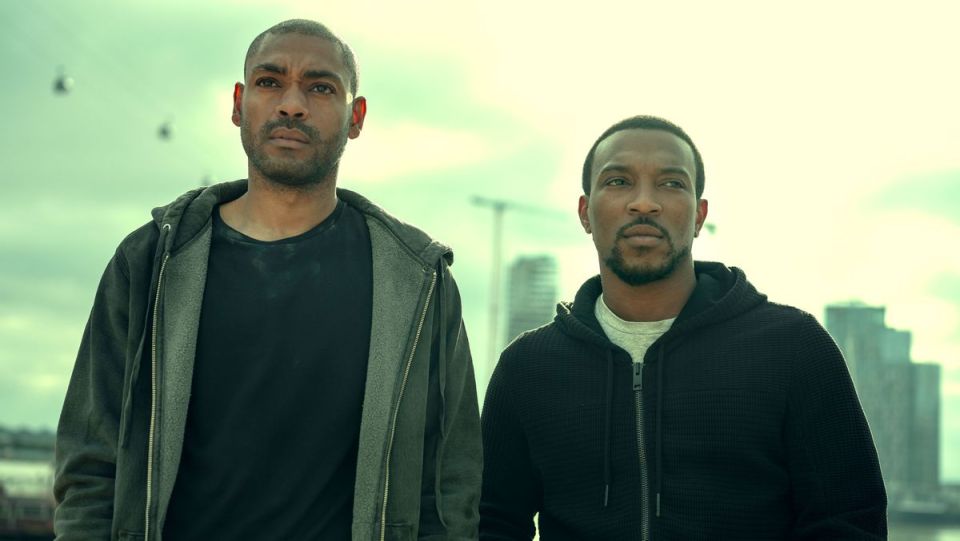 Two men in hoodies standing outdoors.