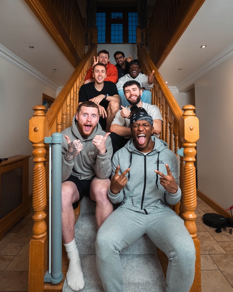 Group of men posing on a staircase.