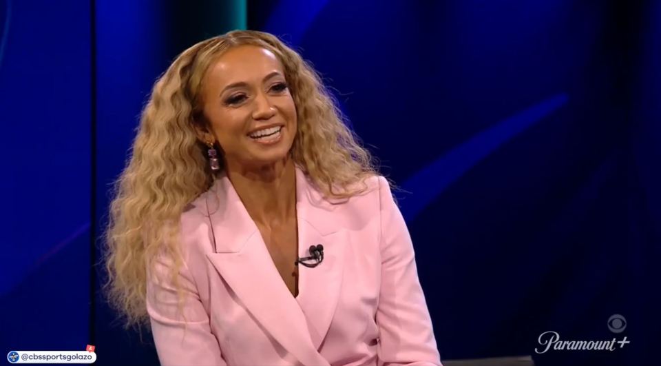 A woman in a pink blazer smiling.