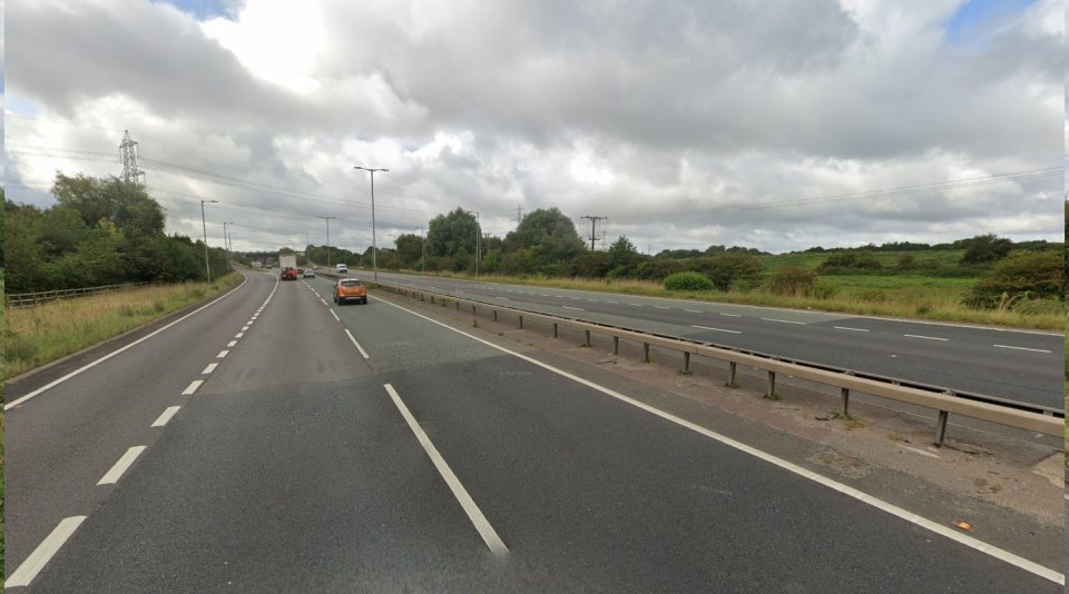 A multi-lane road with cars driving on it.