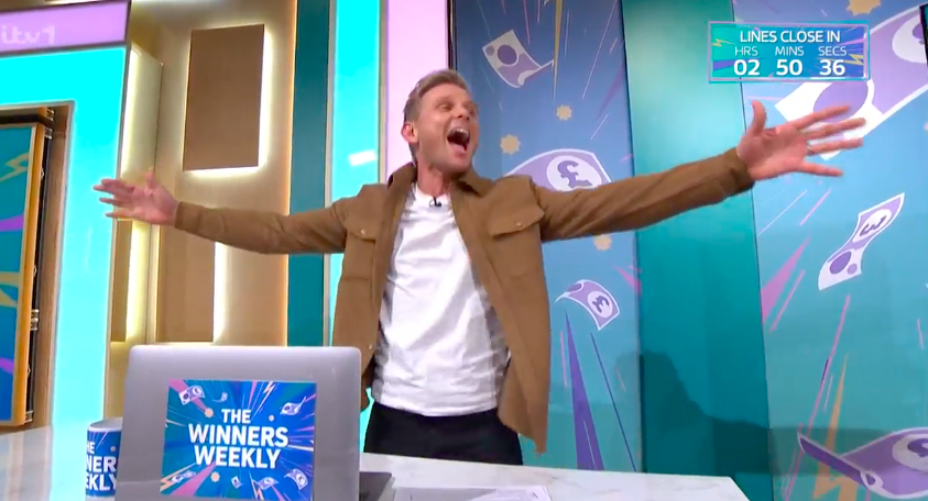 Man celebrating on game show set.