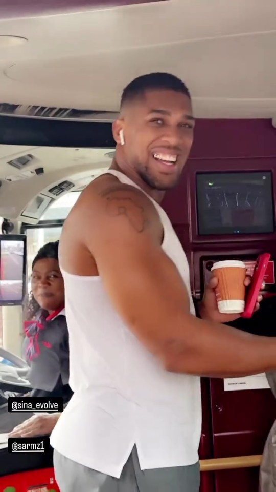 Anthony Joshua greeting fans on a bus.