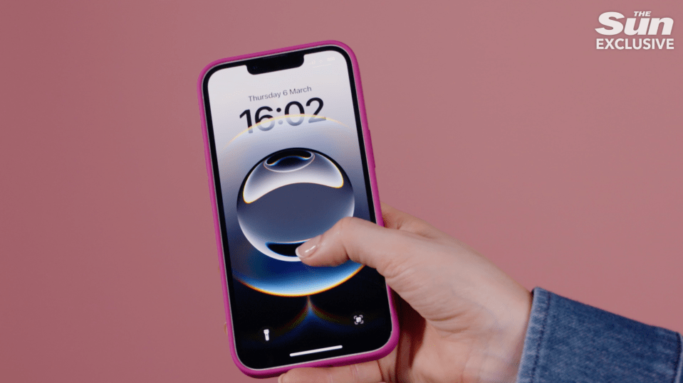 Pink iPhone displaying a lockscreen with an abstract sphere graphic.