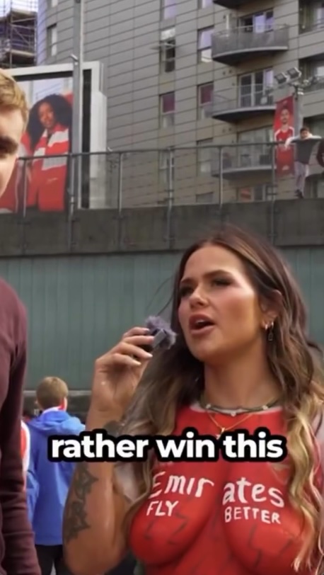 Woman in Arsenal body paint being interviewed.