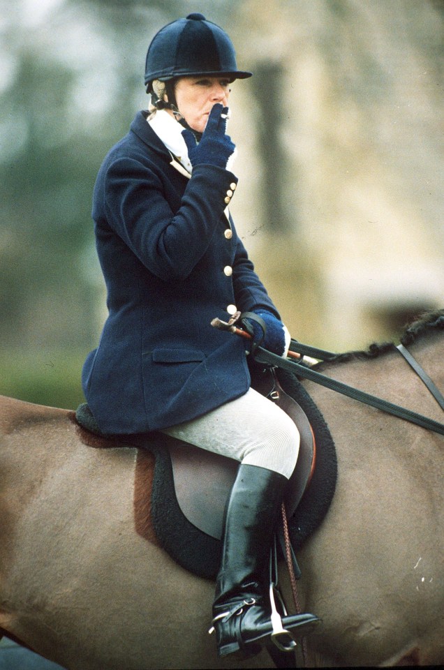 Camilla Parker Bowles riding a horse and smoking a cigarette.