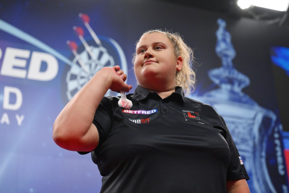 Beau Greaves of England celebrates during a darts match.