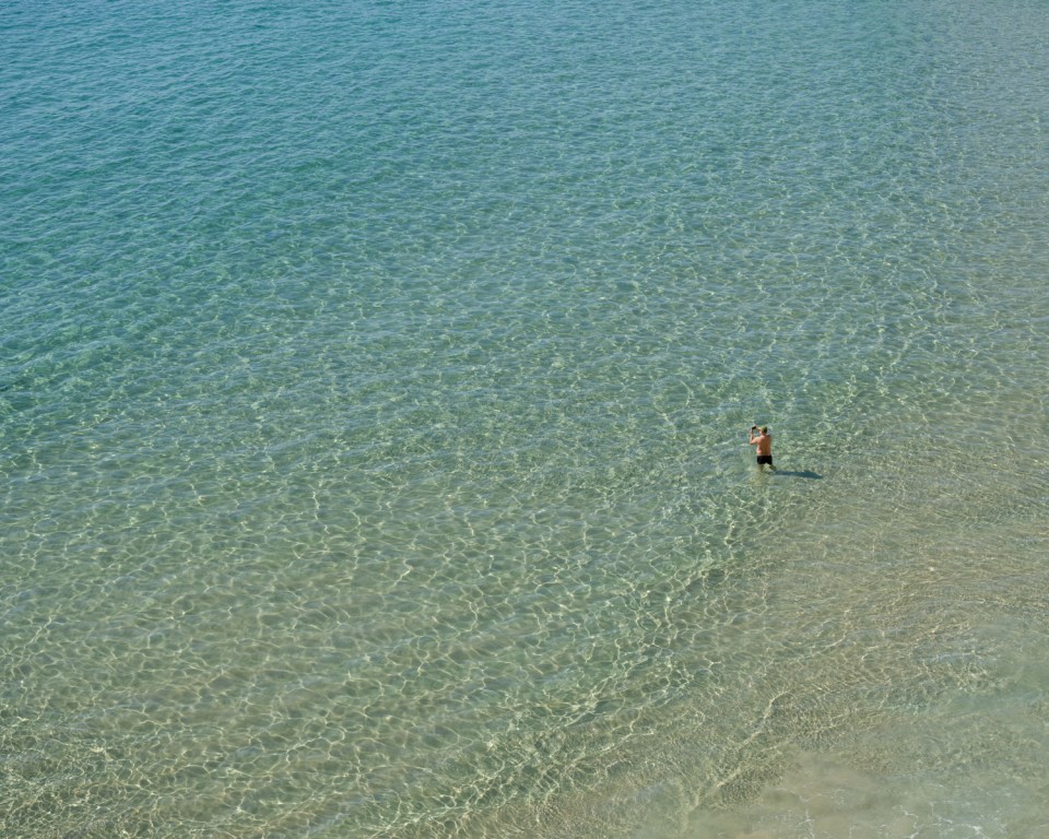 Person wading in shallow, clear water.