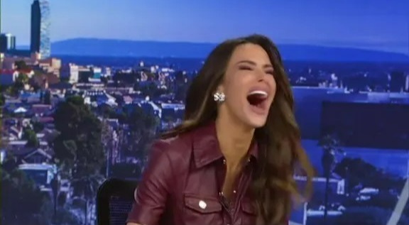 A TV presenter laughing after falling on live television.