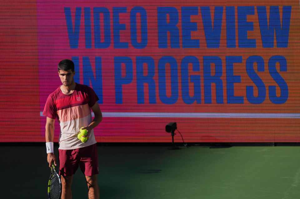 Carlos Alcaraz awaiting a video review during a tennis match.