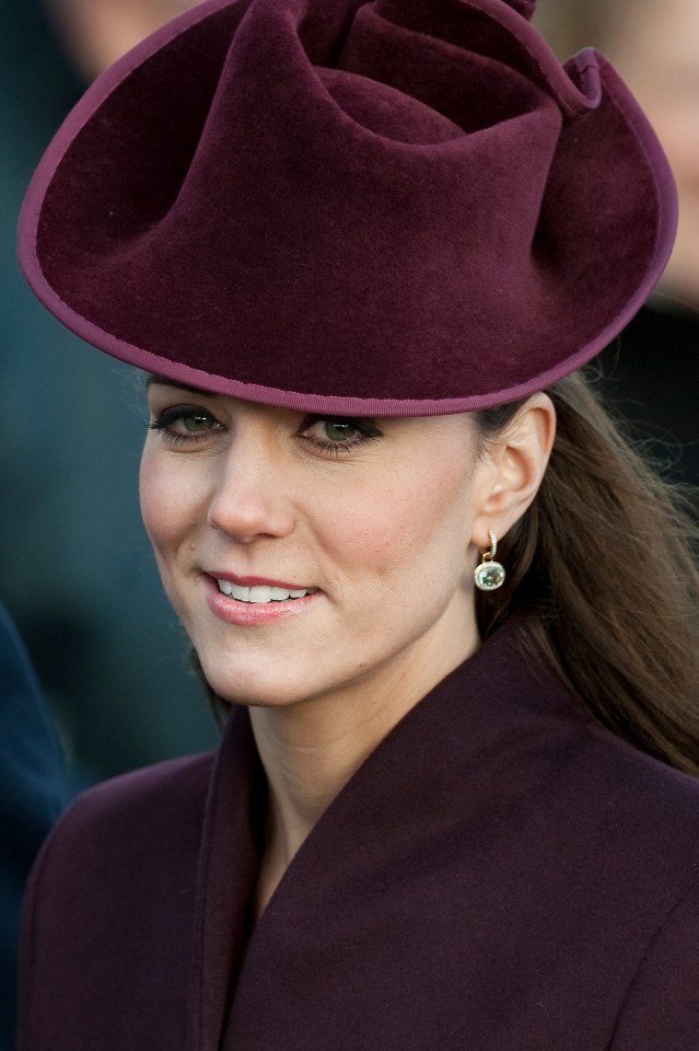 Catherine, Duchess of Cambridge, wearing a burgundy hat and coat.