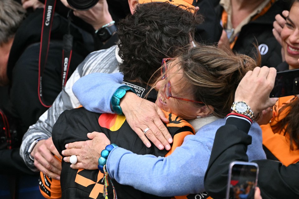 Lando Norris hugging relatives after winning a Formula One race.