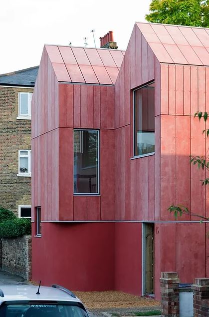 Modernist red house with large windows.
