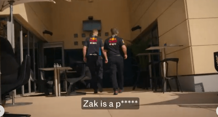 Two men in Red Bull Racing team uniforms walk away from the camera.  Text on the image reads: "Zak is a p*****".