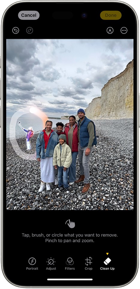 Smartphone screen showing a family photo on a beach with a person being removed using a photo editing tool.