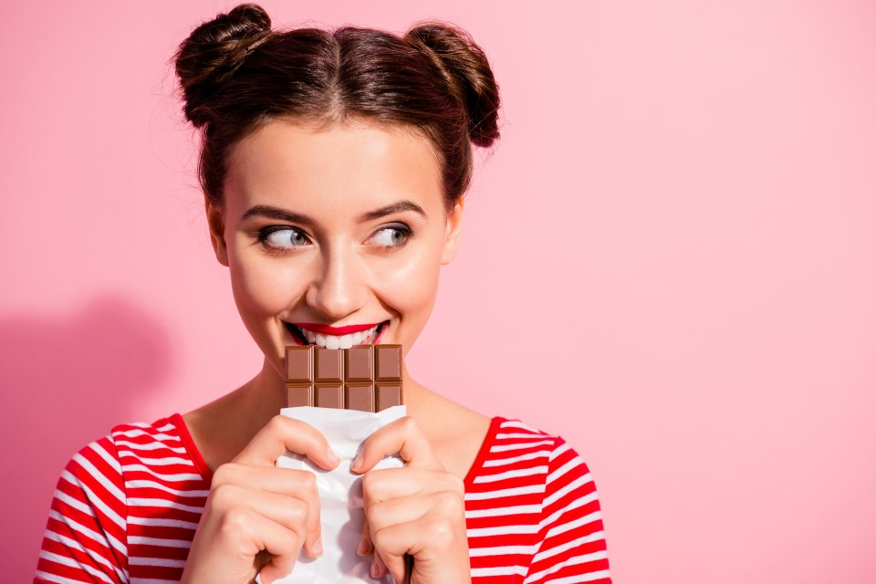 Woman eating a chocolate bar.