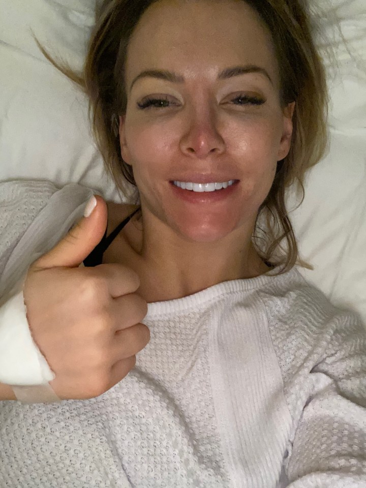 Woman in hospital gown giving thumbs up.
