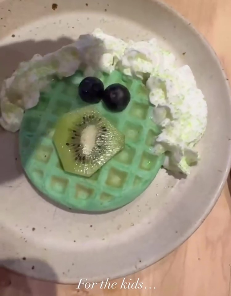 Green waffle with whipped cream, kiwi, and blueberries.