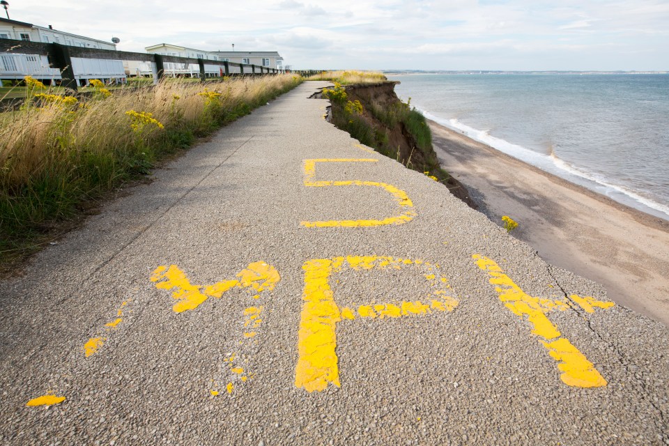 Collapsed coastal road with a 5 mph speed limit sign.