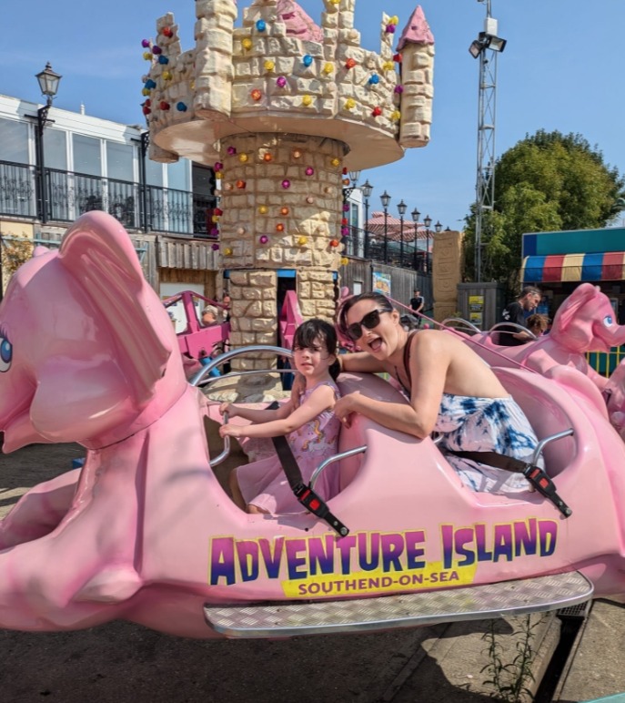Woman and child on a pink elephant ride at Adventure Island, Southend-on-Sea.