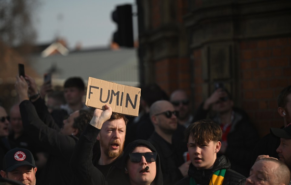 A protestor holds a sign reading "FUMIN'" at a Manchester United protest.