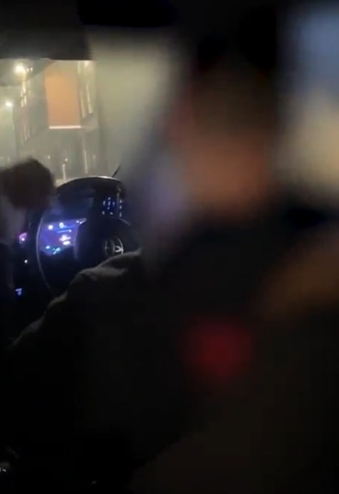 Blurry image of a person driving at night.