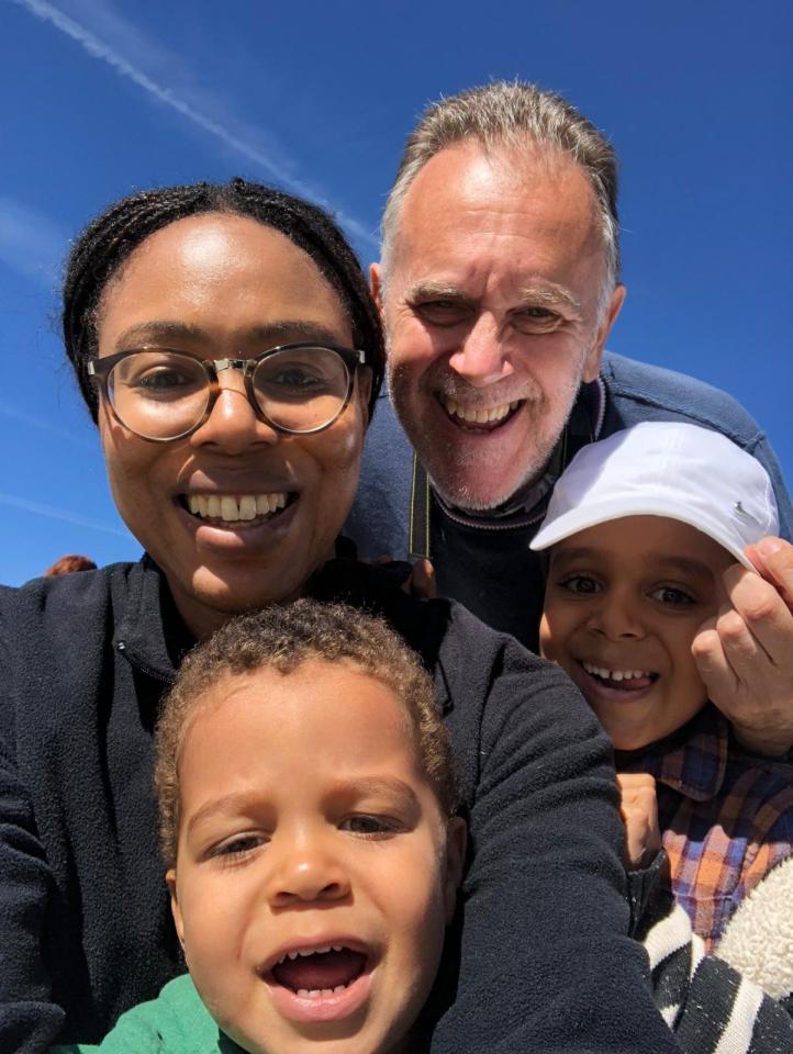 Family selfie against a bright blue sky.