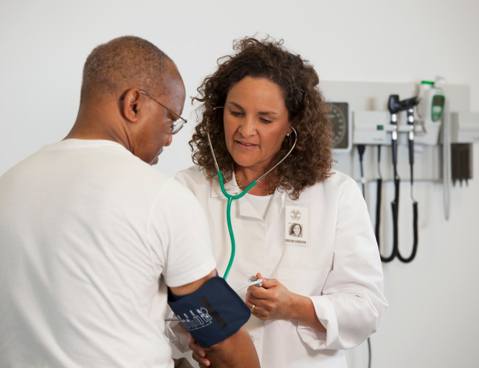 Doctor taking a patient's blood pressure.