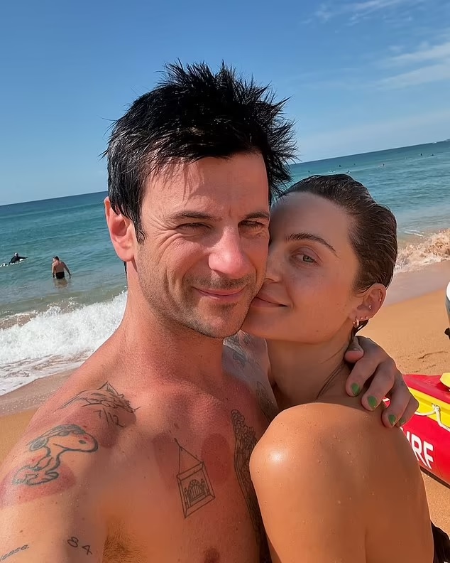 Domenica Calarco and Jarod Bogunovich embracing on a beach.