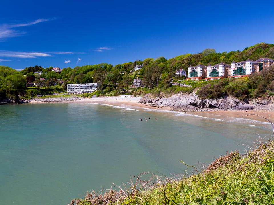 Caswell Bay beach in Wales, with buildings on the hillside.
