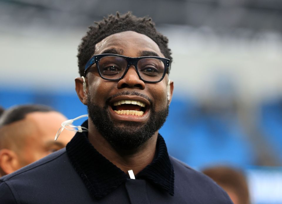 Micah Richards smiling at a soccer match.