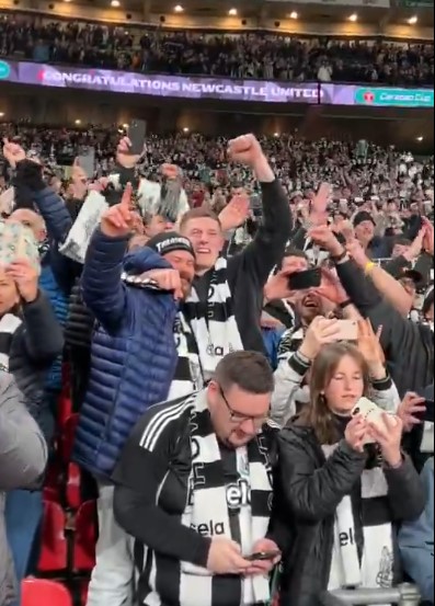 Newcastle United fans celebrating in the stands.