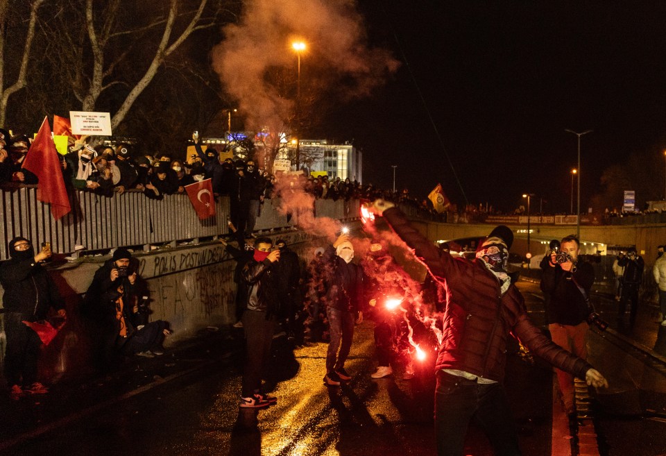 Protester throws a torch at riot police during a demonstration in Istanbul.