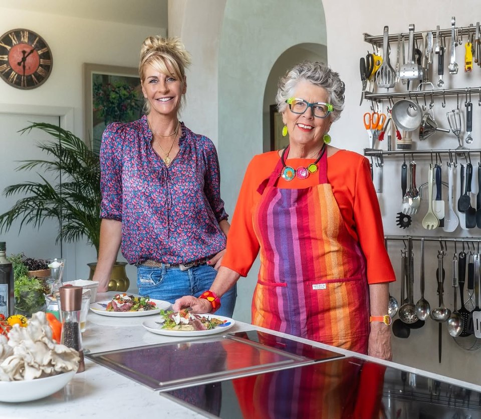 Two women standing in a kitchen, preparing food.