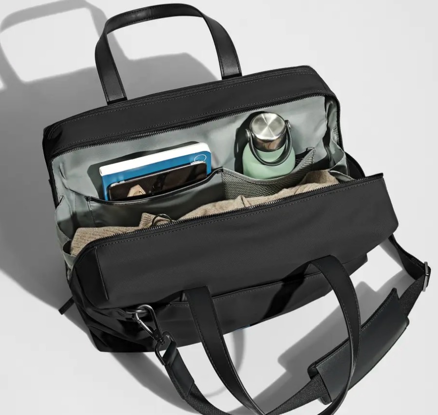 Open black Everywhere Bag with various items inside.