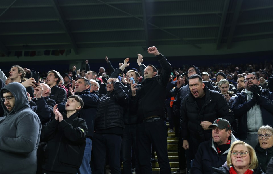 Manchester United fans cheering at a match.