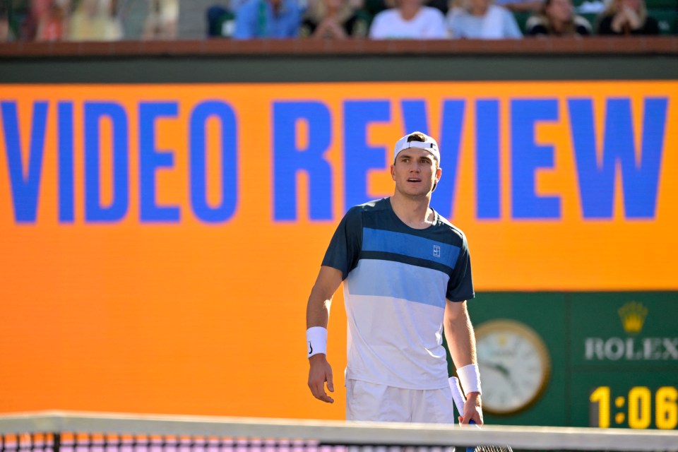 Tennis player Jack Draper watching a video review during a match.