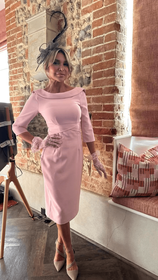 Woman in pink dress and hat.