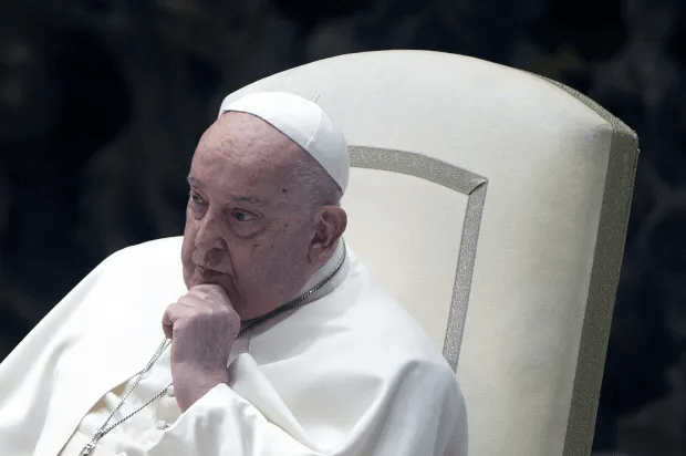Pope Francis seated, hand to chin.