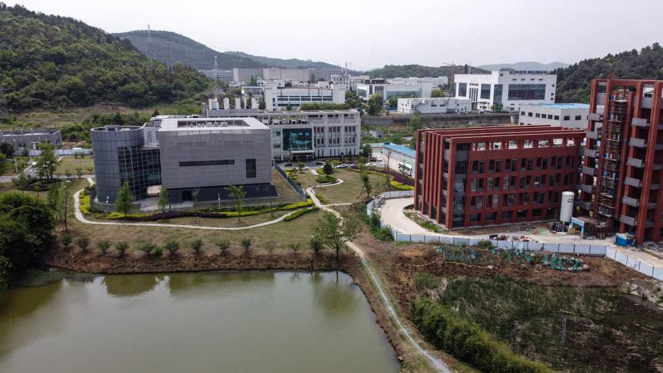 Aerial view of a campus with several buildings and a pond.