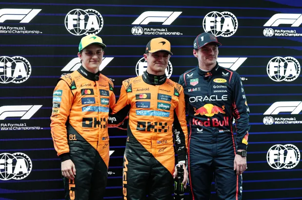 Three Formula 1 drivers standing together.