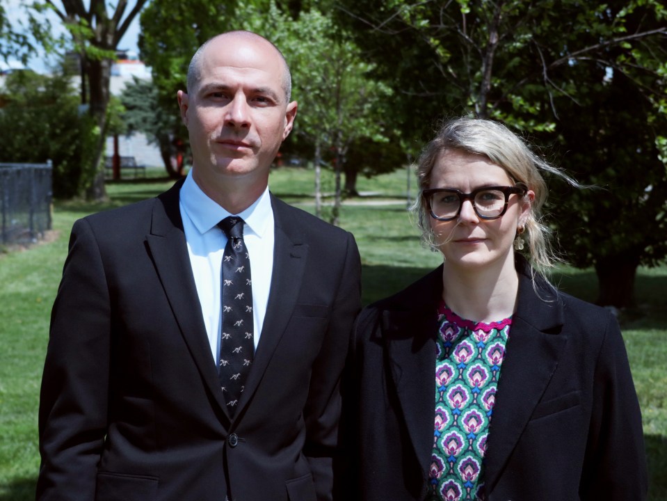 Portrait of a man and woman in business attire outdoors.