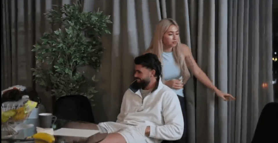 A man and woman sitting near a window.